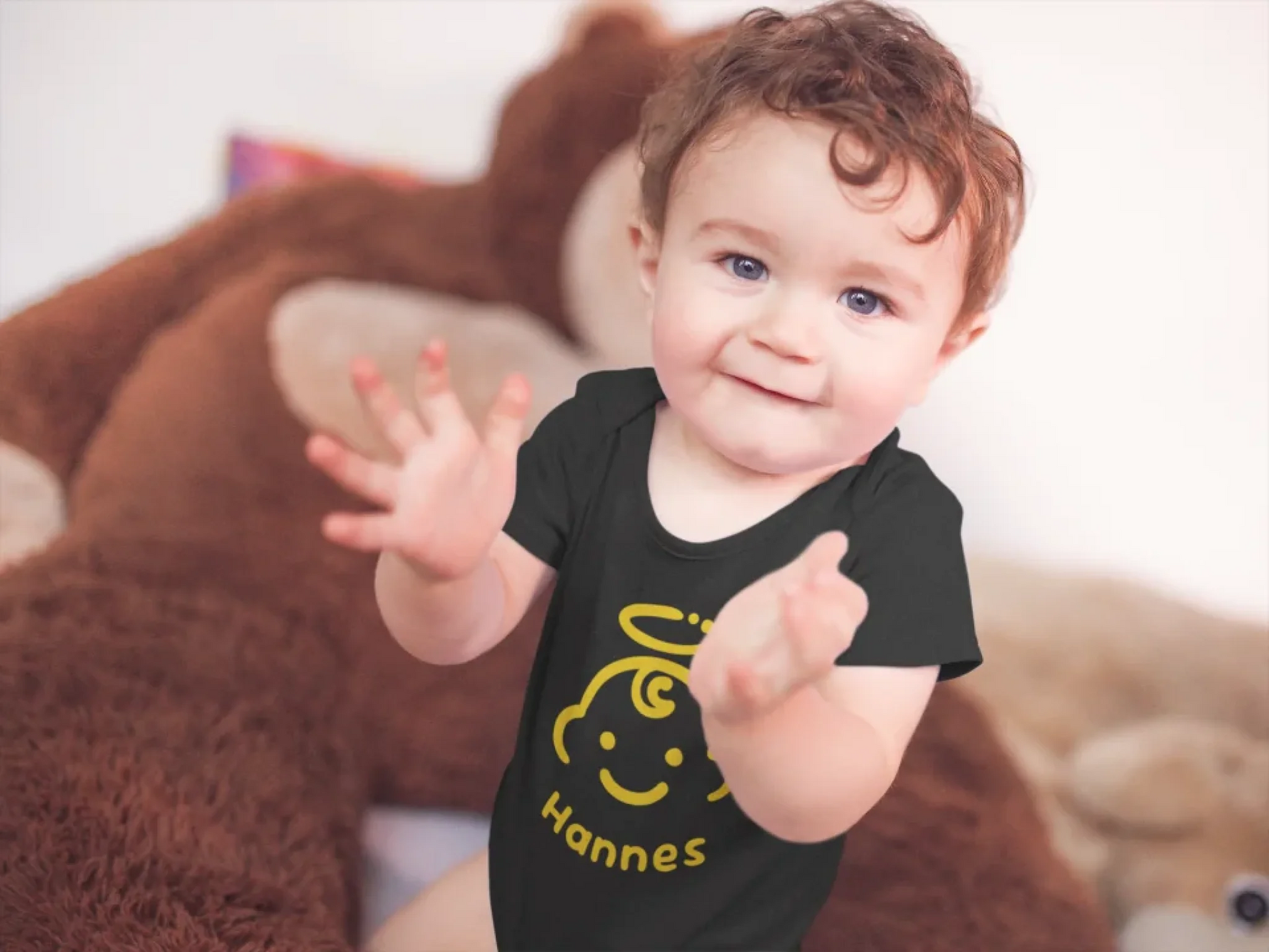 baby-boy-clapping-sitting-down-wearing-a-onesie-with-a-monkey-plush-in-the-background-mockup-a14022